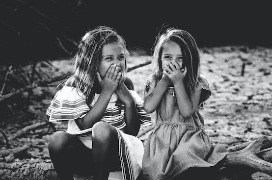 Deux petites filles qui rigolent dans la nature en noir et blanc